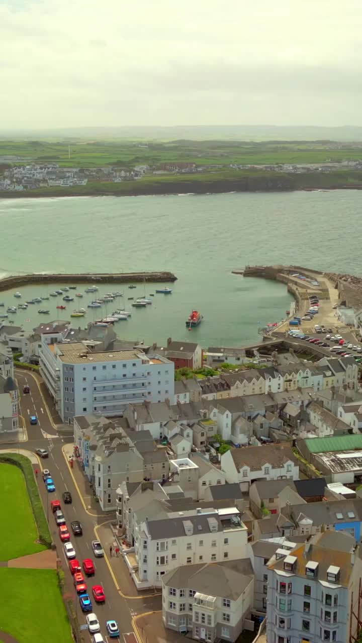 Reversing social ratio aerial video of the bay at Portrush West Strand Beach in County Antrim, Northern Ireland, UK on a sunny day. Produced in 1080x1920 vertical ratio, 60FPS and with Rec709 color