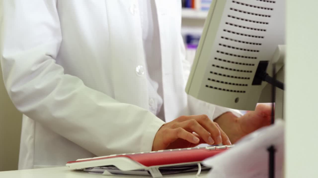 farmacéutico haciendo un registro de recetas en la computadora