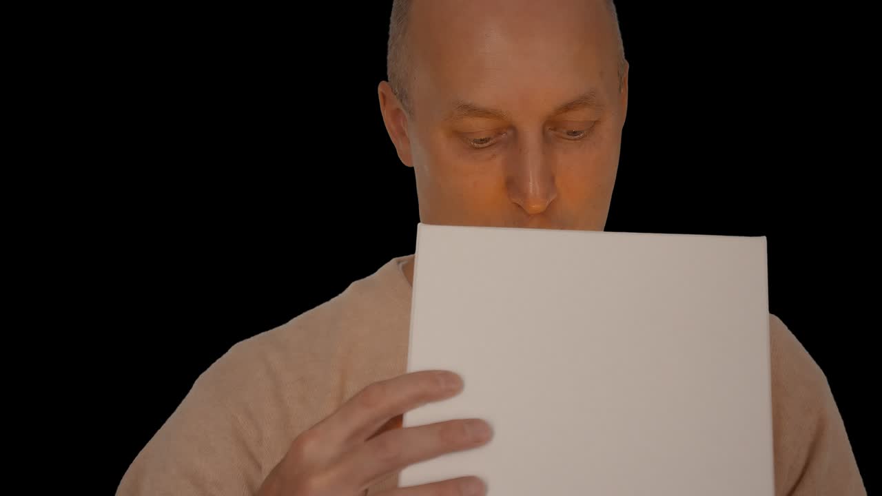 A happy man was given a gift. The man looked in the gift box and was very inspired. A joyful man is very grateful for the gift. Alpha channel chroma key transparent background.