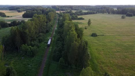 Narrow-gauge-railroad-train-moving-through-country-side-landscape-aerial-view