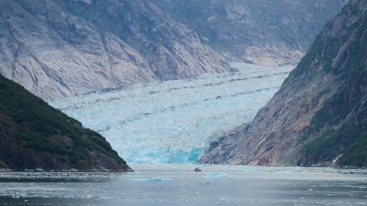 Small boat approaching Dawes Glacier, Endicott Arm fjord, Alaska.