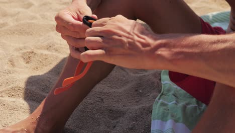 man adjusting sunglasses on beach