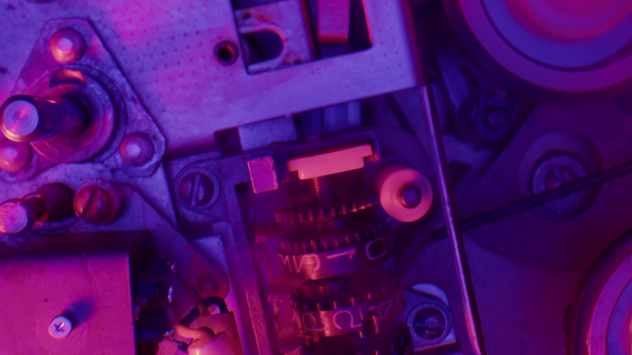 primer plano de piezas de máquinas antiguas con luz de neón púrpura