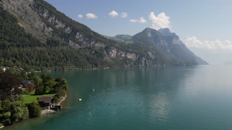 Drone-Volando-Sobre-La-Ciudad-De-Weesen-Cerca-De-La-Orilla-Del-Lago-Walensee,-Suiza-Con-Cielo-Azul