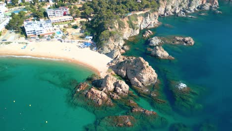 turquoise waters caressing golden sands alongside rocky outcrops, creating stunning mediterranean coastline contrast near costa brava's scenic shoreline