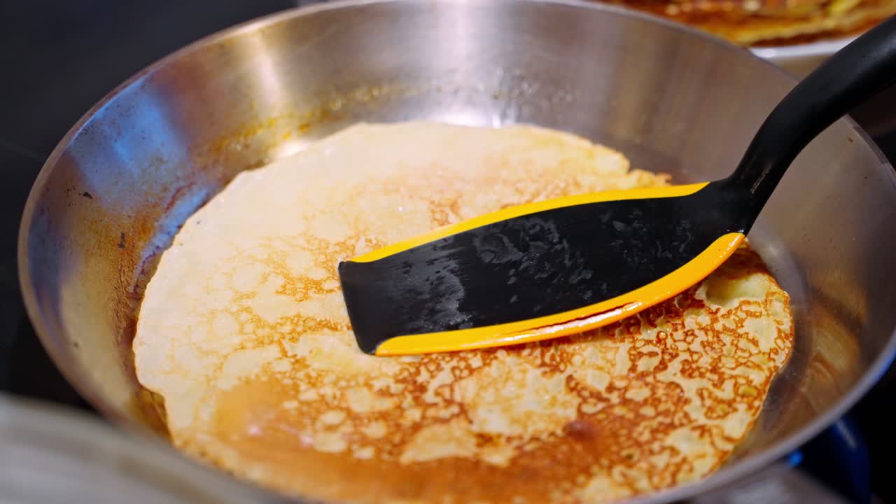 황금 팬케이크가 뜨거운 비에 여 있으며, 스파라를 사용하여 완벽한 아침 식사를 할 수 있습니다.