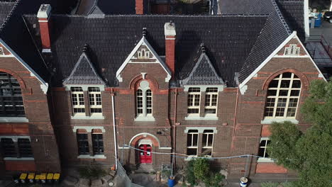 drone ascend and reveal old church turned into a school with active renovations and maintenance