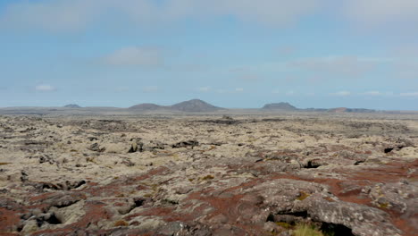 Luftaufnahme-über-Die-Surreale-Und-Mondlandschaft-Von-Island.-Drohnenblick-über-Die-Felsenwüste-Mit-Bergen-Im-Hintergrund