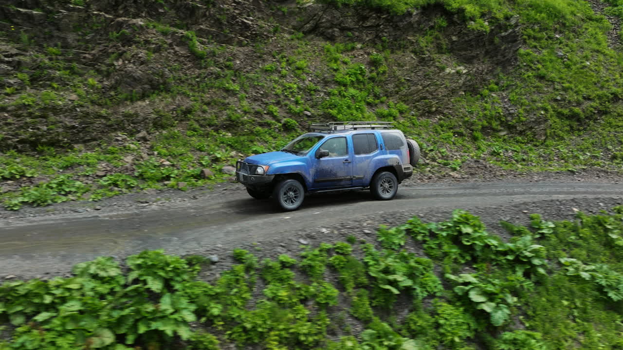 SUV che guida sul fangoso Passo di Abano, la strada di montagna più pericolosa nel Tusheti, Georgia