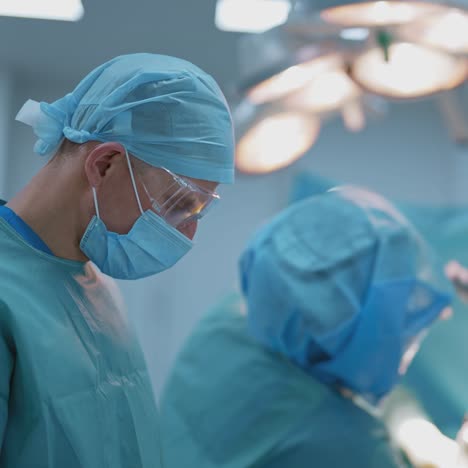 operating theater. team of doctors doing a surgery to a patient lying on operating table. group of surgeons in medical uniform in operating room