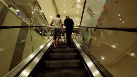 visitors using the electric staircase, escalator as transportation between floors of shopping complex