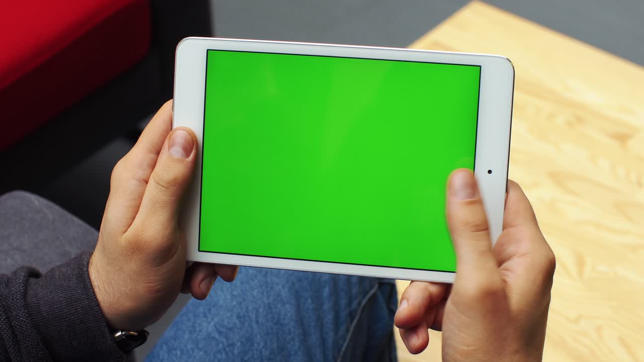 Man holding a tablet with green screen