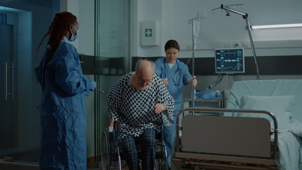Nurse and african american doctor helping seat sick patient