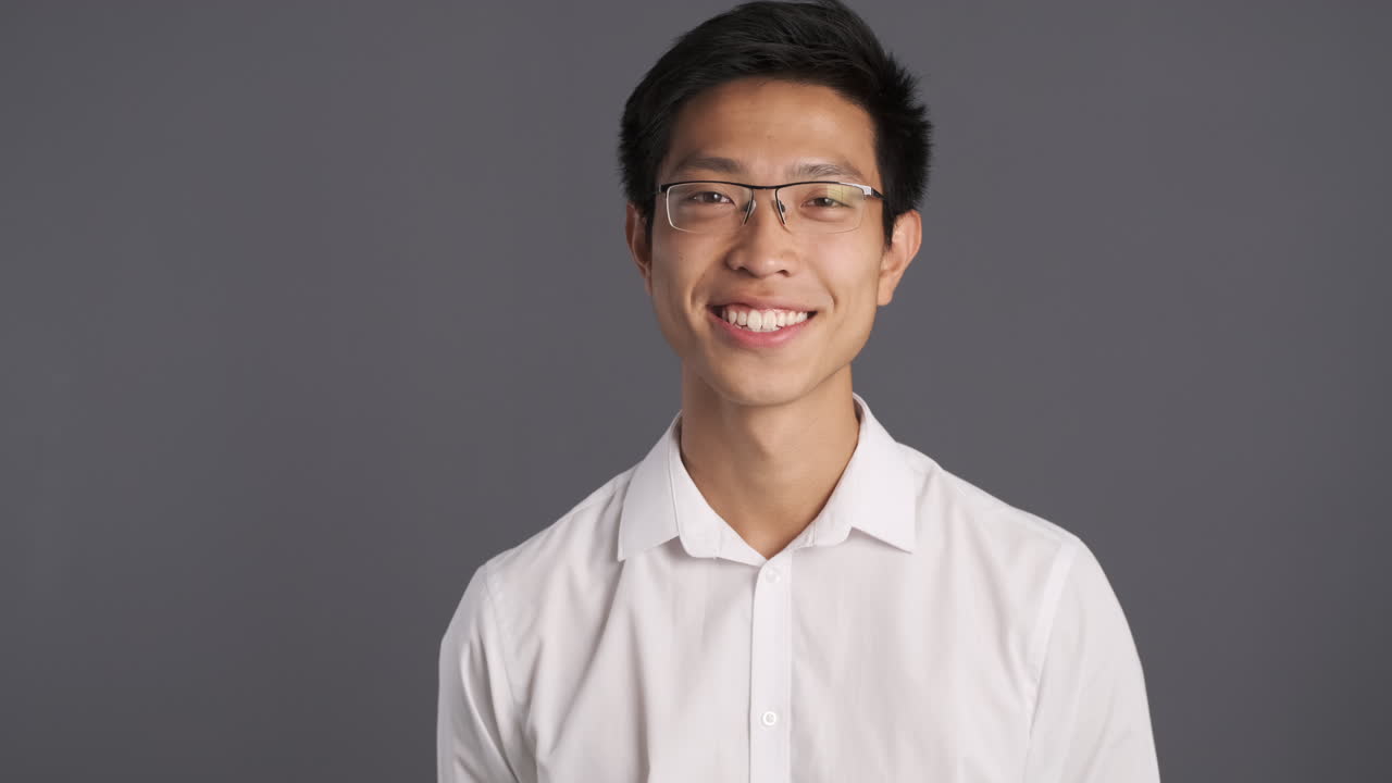 카메라 앞에서 고개를 끄덕이는 아시아인.