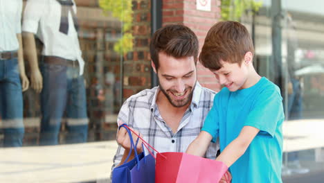 padre e hijo mirando en la bolsa de compras
