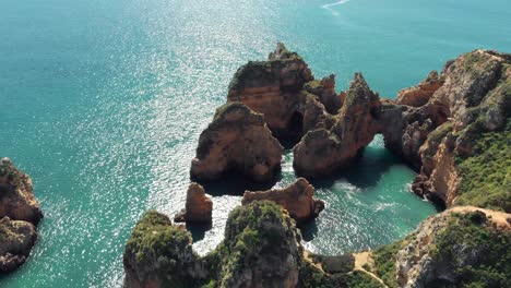 Stone-Arch-'Catedral'-in-Algarve-Coastline-in-Lagos-Portugal---Aerial-Orbit-slow-tilt-up-shot