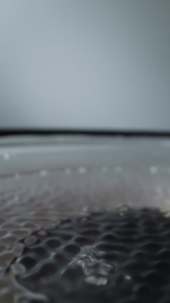 Loudspeaker dynamic moves rhythmically creating ripples on water on diaphragm. Covered with layer of soapy water electric device for playing music macro