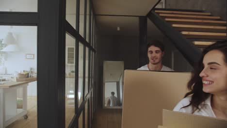 happy couple with boxes moving to new apartment. couple hugging at kitchen.