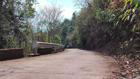una motocicleta de tres ruedas está conduciendo en una carretera de montaña