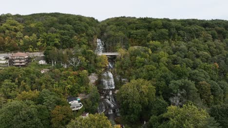 hector falls - gigantic waterfall flowing through the forest in autumn in new york, usa