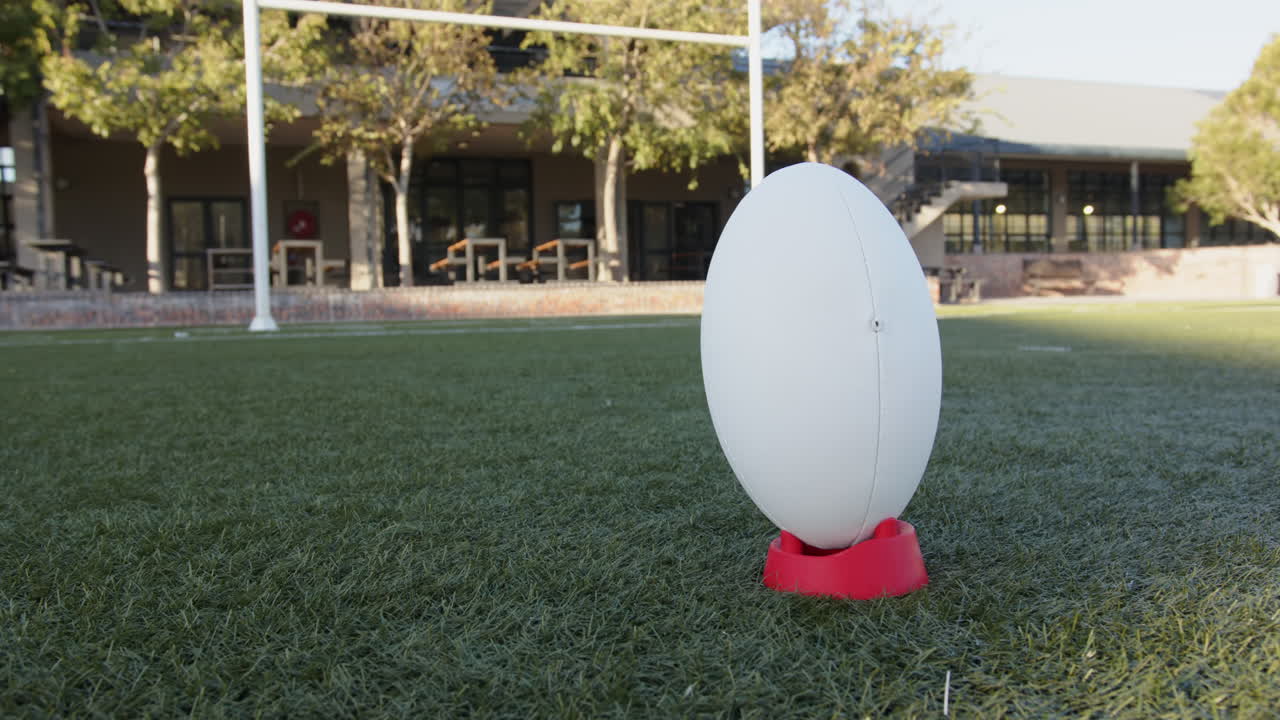 Rugby ball on tee on field, ready for kick-off during sports practice, copy space