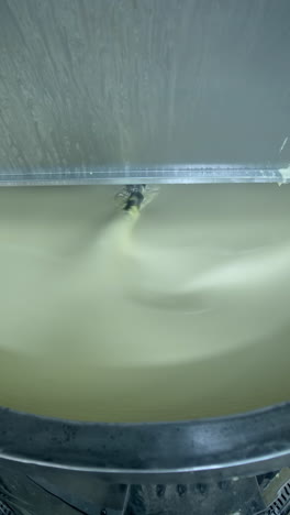 industrial equipment for making butter. modern container mixing butter at milk factory. creamy dairy product in a tank.. vertical video
