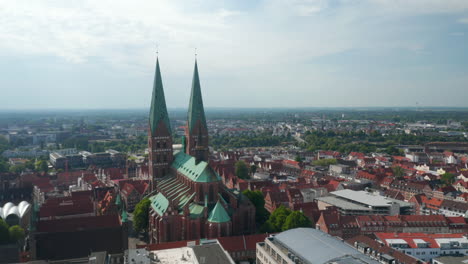 Vista-Aérea-Del-Casco-Antiguo.-Orbitando-Alrededor-De-Marienkirche,-Iglesia-Parroquial-Principal.-Edificio-Religioso-Gótico-De-Ladrillo.-Lübeck,-Schleswig-Holstein,-Alemania