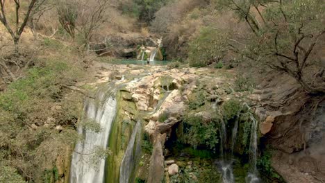 Volando-Hacia-Un-Hombre-Parado-En-Una-Roca-En-La-Cascada-Superior-Disfrutando-De-La-Vista-De-La-Naturaleza-En-El-Parque-Cascada-De-Comala-Cerca-De-Chiquilistlán,-Jalisco,-México