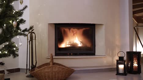 Still-shot-of-a-Cozy-modern-fireplace-during-the-christmas-eve-celebration-with-a-pine-tree-and-a-wicker-empty-basket