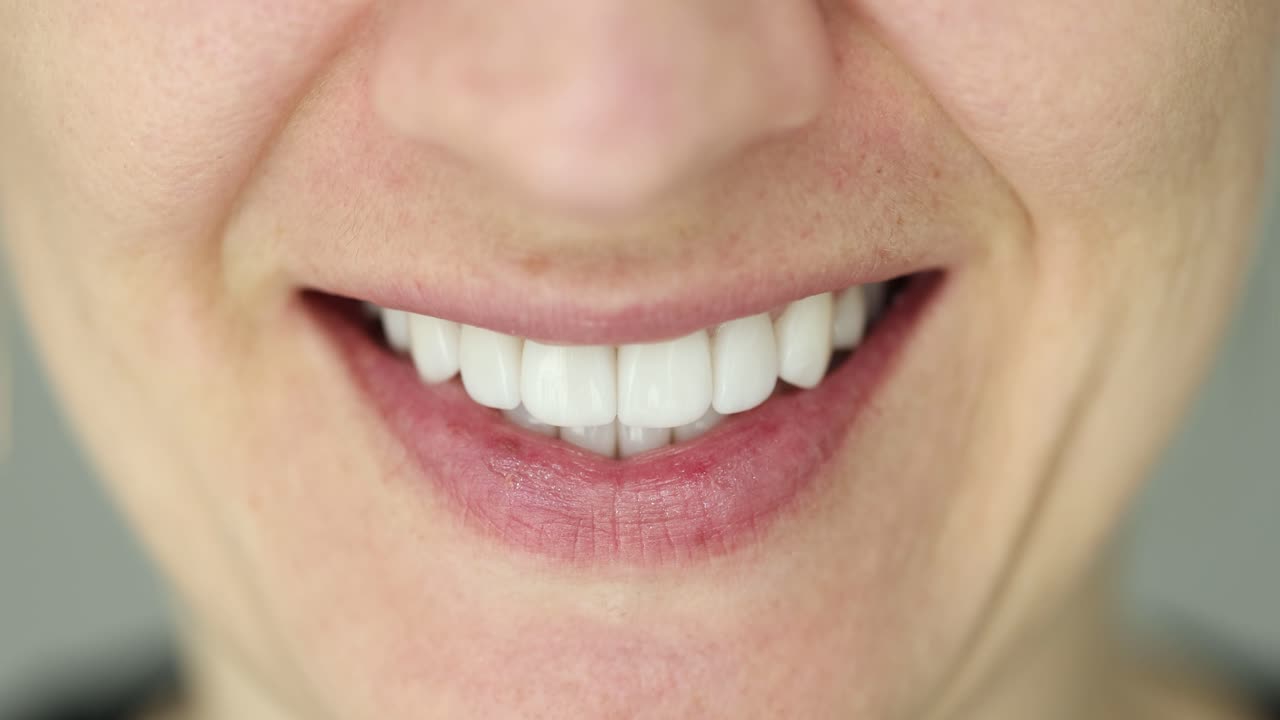 Close-up of a person smiling and showing white teeth