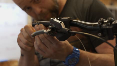 Close-up-of-bike-mechanic-tightening-a-screw-on-a-brake-lever