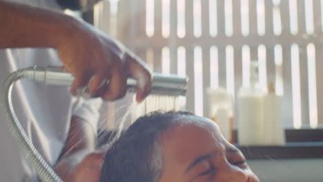 african american boy getting his hair washed by dad