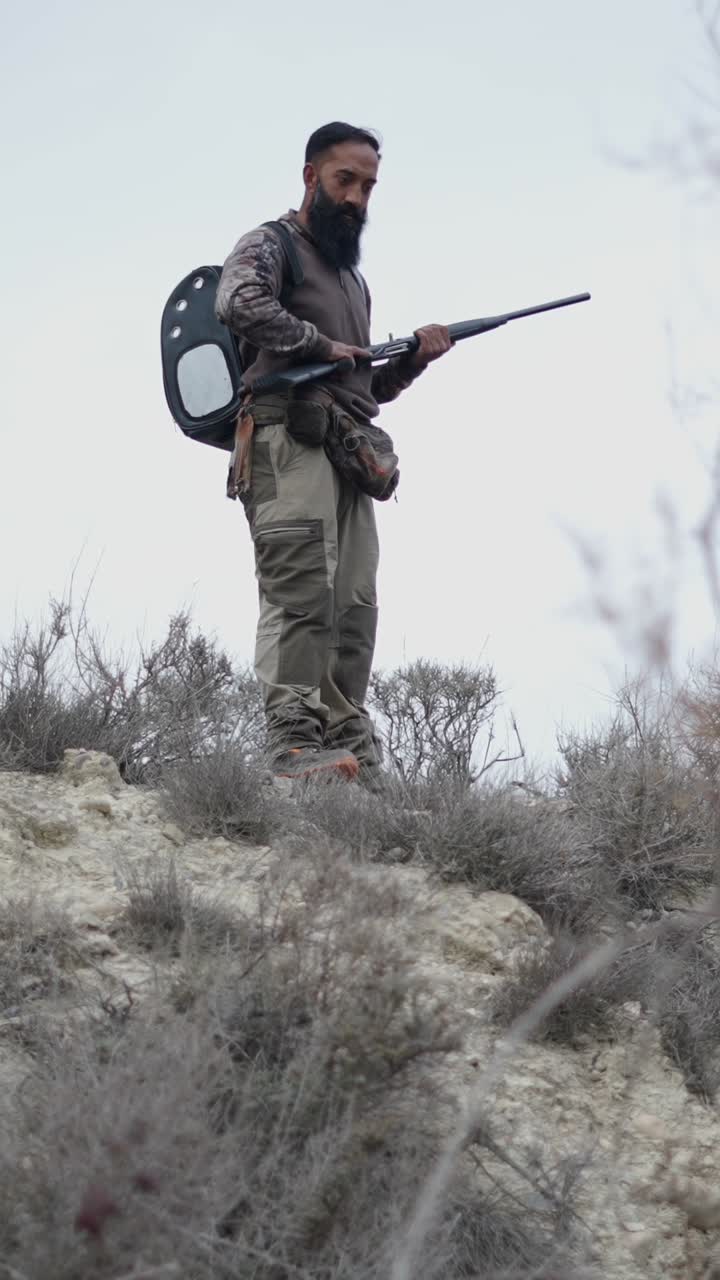 Hunter with Rifle in Rural Landscape