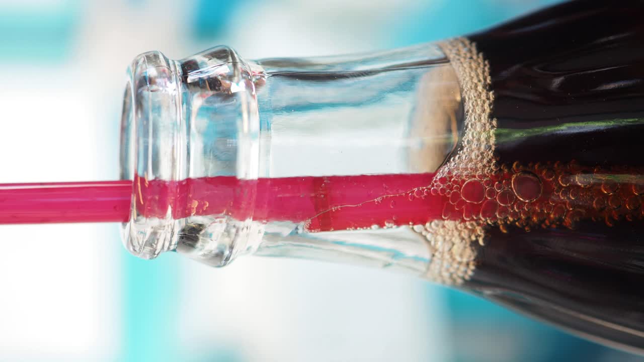 Close-up of a soda bottle with a straw