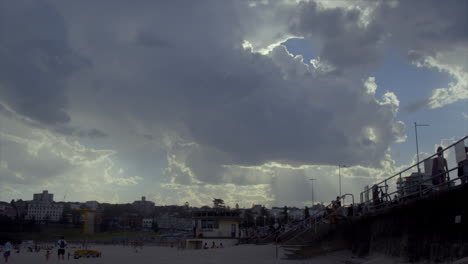 sunlight breaking through clouds over a beach with a lifeguard station