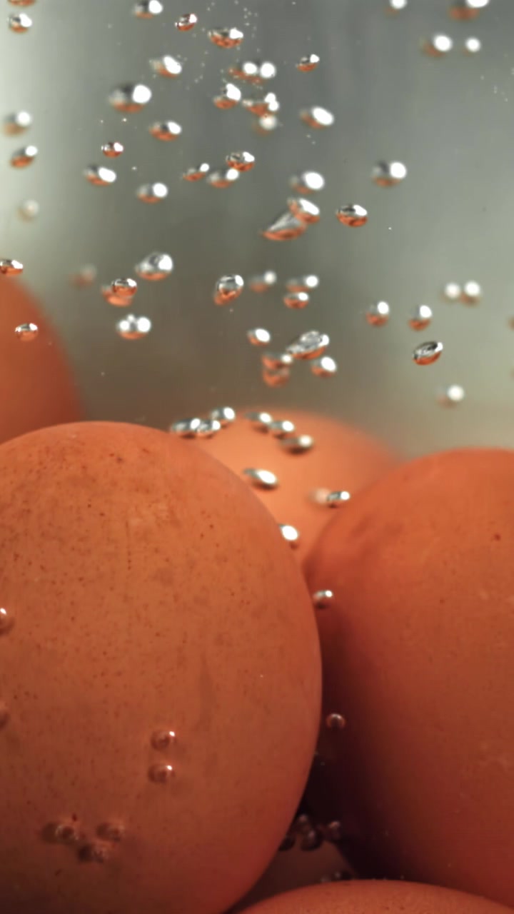 Brown Eggs Cooking in Boiling Water with Rising Bubbles
