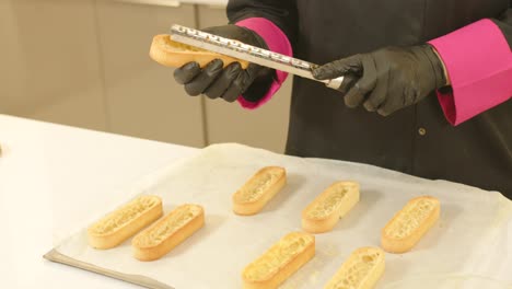 Close-up-gimbal-shot-of-gloved-hands-mending-ready-made-tartlet-doughs