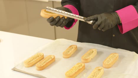 primer plano de cardán de manos enguantadas remendando masas de tartaletas preparadas
