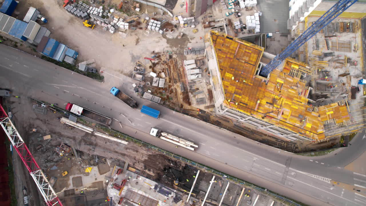 Bird's-eye view of a construction site beside a busy road with traffic