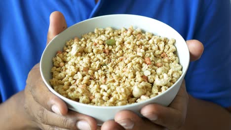 person holding a bowl of granola