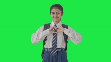 Happy-Indian-school-girl-showing-heart-sign-Green-screen