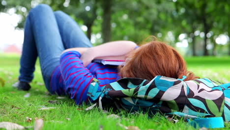 Hübsche-Junge-Studentin-Liegt-Auf-Dem-Gras-Auf-Ihrer-Büchertasche