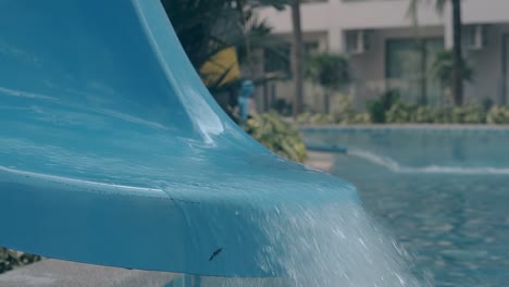 el flujo de agua cae desde el tobogán en la piscina clara cámara lenta