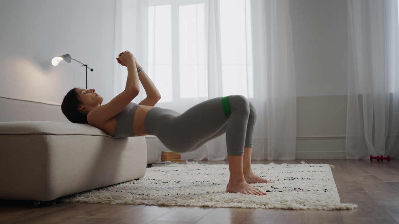 Donna che fa allenamento per il core a casa con una fascia elastica