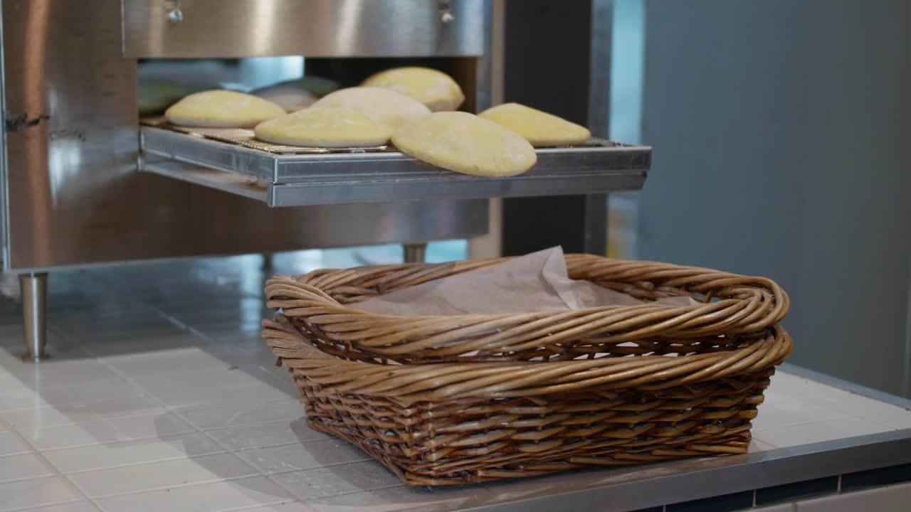 Pita Bread freshly cooked are falling into wooden baskets ready to be packaged for eating
