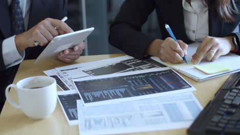 profesionales de las finanzas que usan tabletas y escriben notas