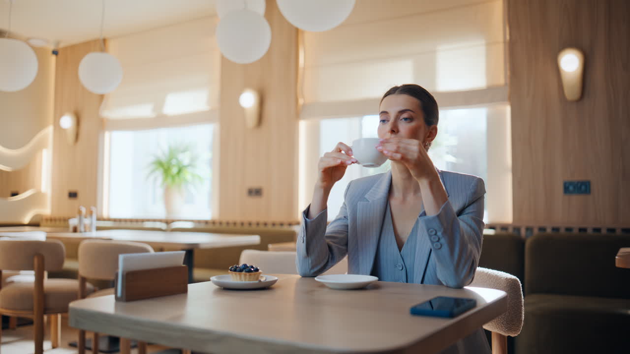 Elegant dame, der nipper til kaffen på restaurant tæt på. Forretningskvinde, der slapper af alene