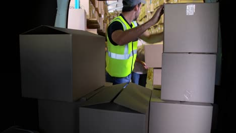 delivery driver loading his van with boxes