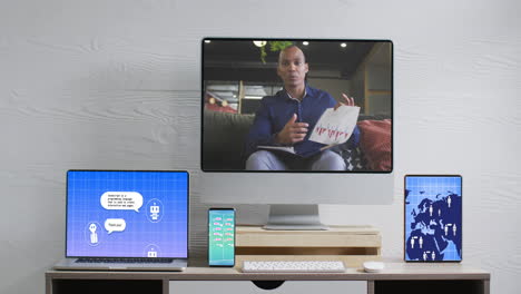 empresario afroamericano en videollamadas y dispositivos electrónicos con procesamiento de datos en pantallas