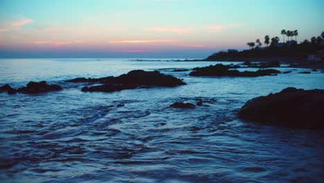 slow motion waves at a rocky beach during twilight